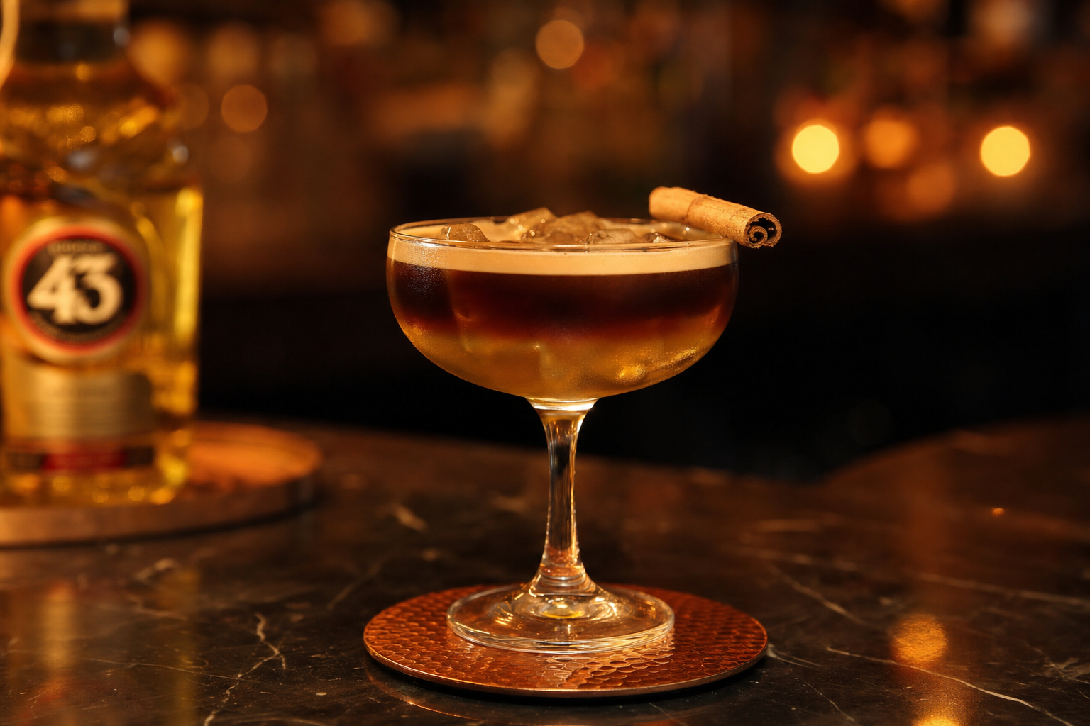 Carajillo cocktail with espresso and Licor 43 over ice with a cinnamon stick garnish