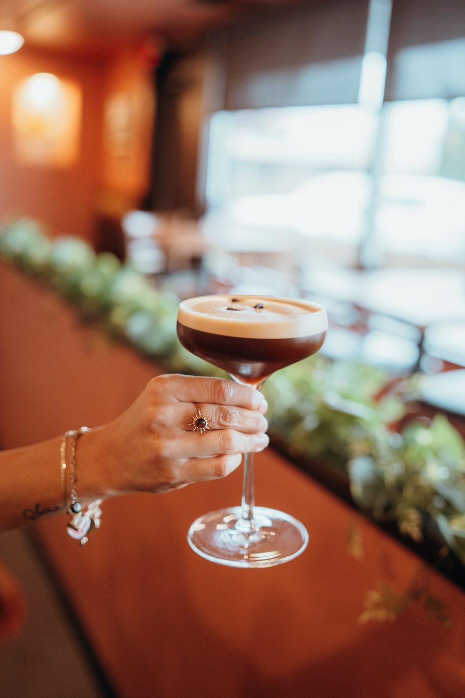 Hand holding an espresso martini at Canela