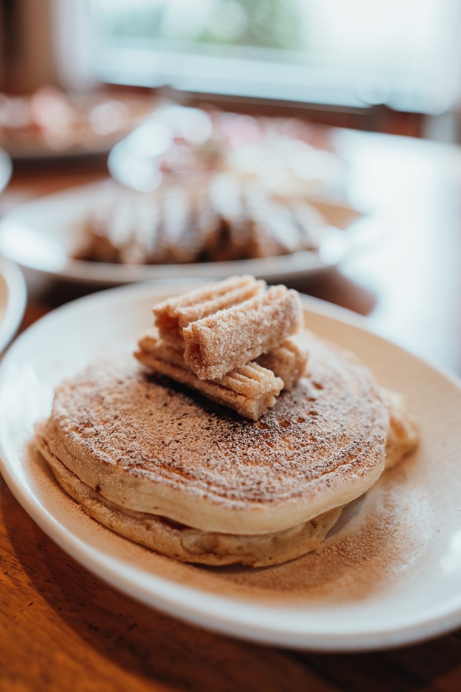 Canela Pancake topped with cinnamon-sugar churros and caramel drizzle