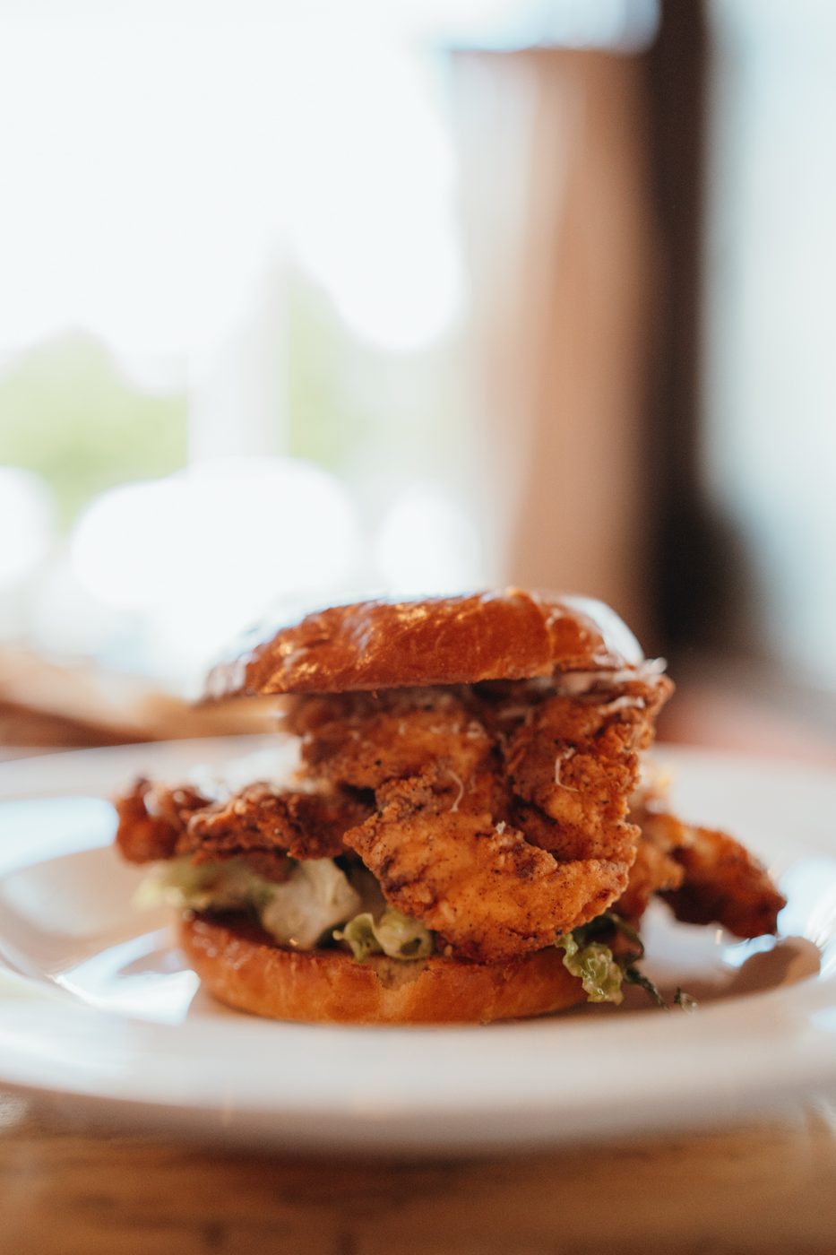Crispy Chicken Caesar Sandwich on a brioche bun with house fries